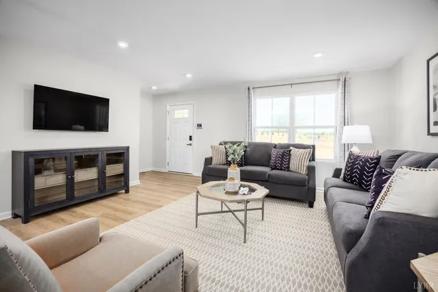 a living room with furniture a fireplace and a flat screen tv