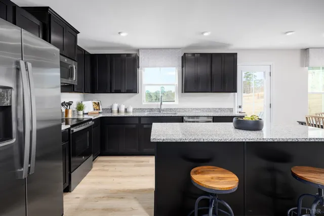 a kitchen with stainless steel appliances granite countertop a sink counter space and chairs