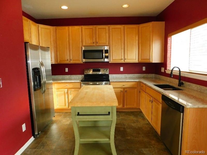 a kitchen with a sink a counter top space cabinets stainless steel appliances and a window