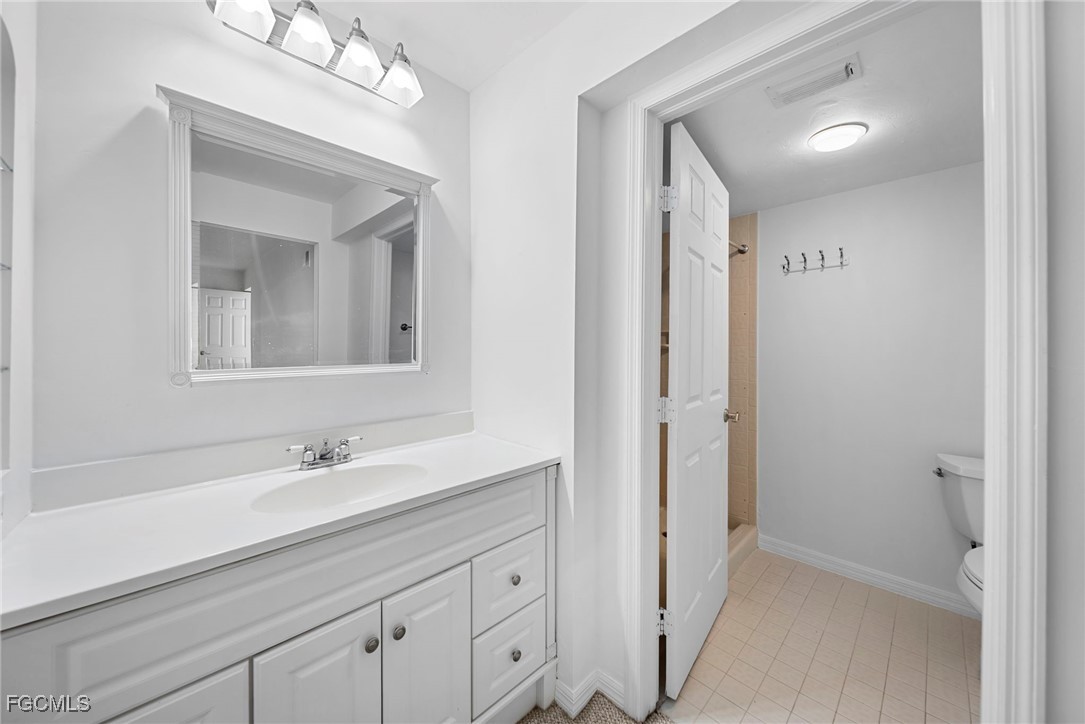 3052 Kings Lake Boulevard, Unit 7554 Naples, FL 34112 - Photo 22 of 32 a bathroom with a double vanity sink mirror and