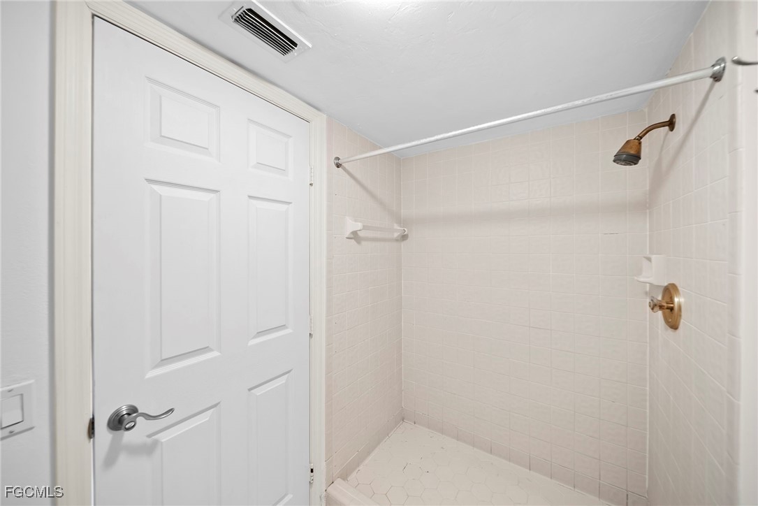 3052 Kings Lake Boulevard, Unit 7554 Naples, FL 34112 - Photo 23 of 32 a bathroom with a shower and toilet