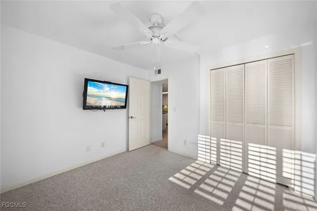 a view of a livingroom with wooden floor and a ceiling fan