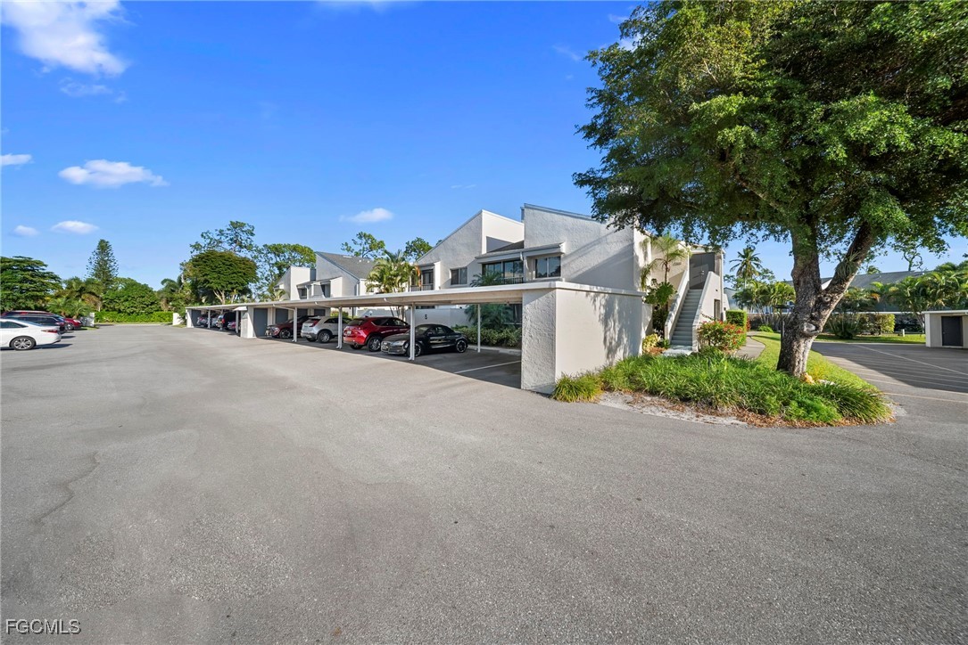 3052 Kings Lake Boulevard, Unit 7554 Naples, FL 34112 - Photo 30 of 32 a view of a street with a building and a street view