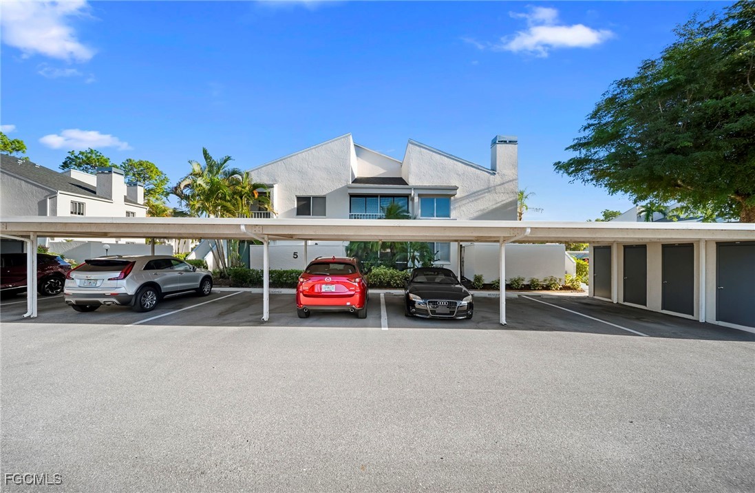 3052 Kings Lake Boulevard, Unit 7554 Naples, FL 34112 - Photo 31 of 32 a view of a cars park in front of a building