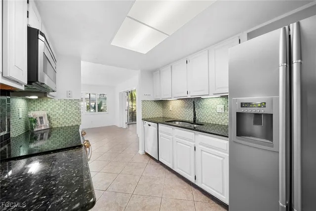 a kitchen with stainless steel appliances granite countertop a sink a stove and a refrigerator