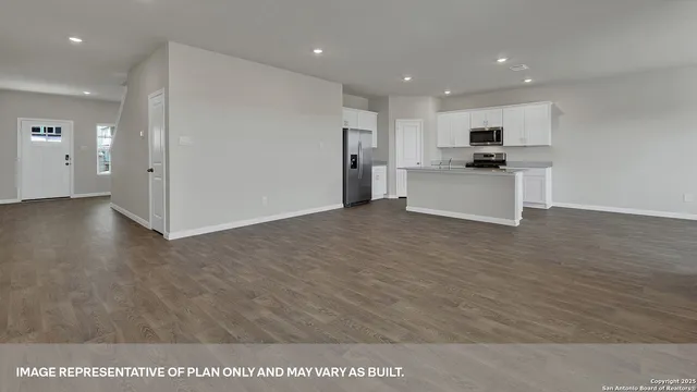 a view of kitchen with kitchen island granite countertop a stove and a refrigerator