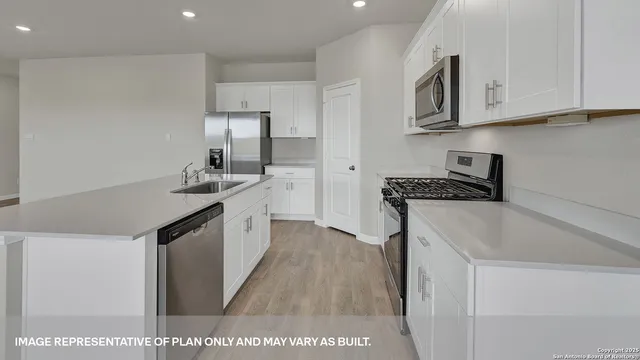 a kitchen with white cabinets sink and stainless steel appliances
