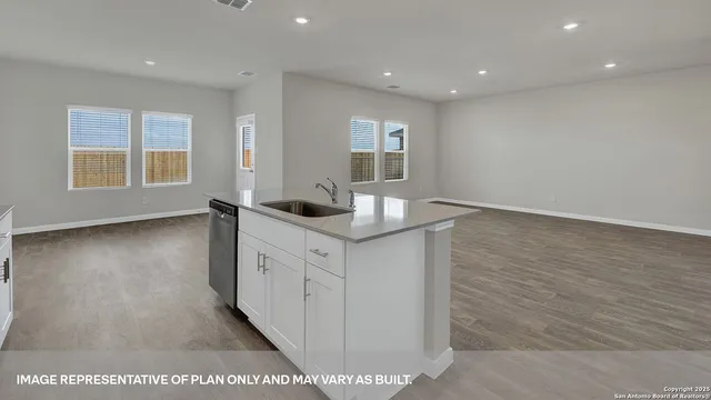 a room with granite countertop white cabinets and wooden floor