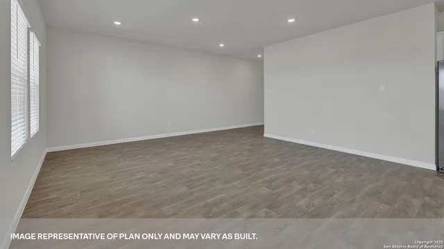 an empty room with wooden floor and window