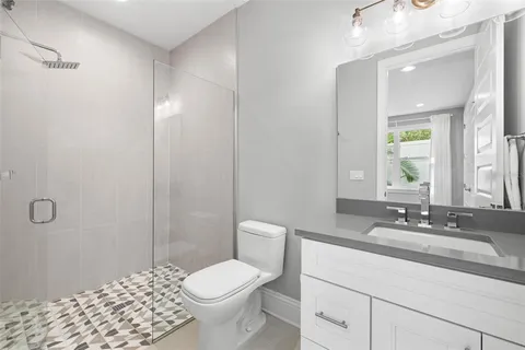 a bathroom with a sink a toilet and shower