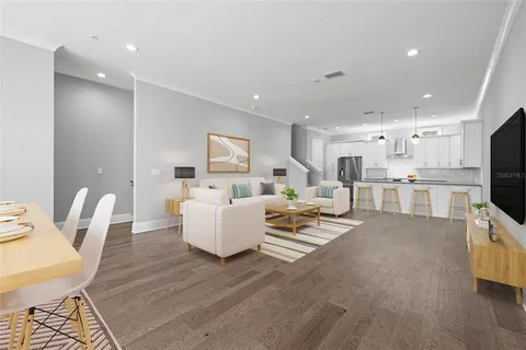 a living room with furniture and a wooden floor