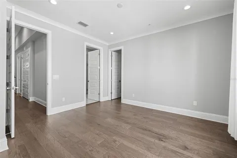 a view of empty room with wooden floor and entryway