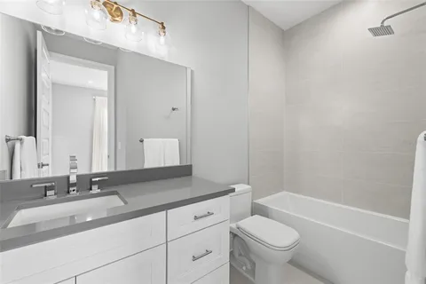 a white toilet and tub sitting next to a bathroom sink