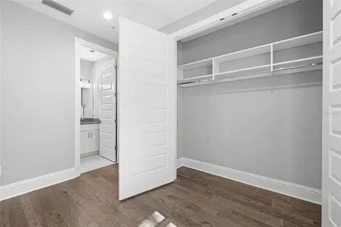 a view of an empty walk in closet with wooden floor