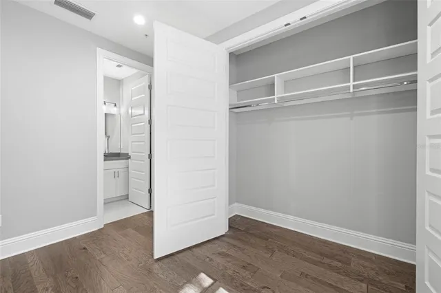 a view of an empty walk in closet with wooden floor