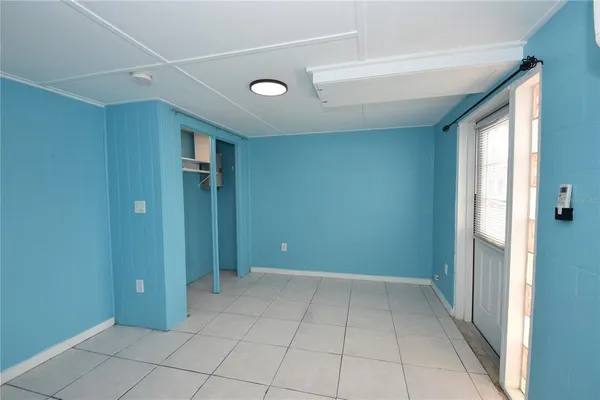 an empty room with windows and closet