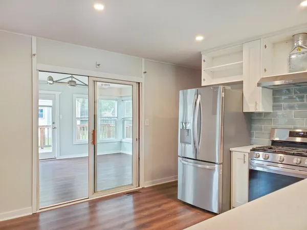 a kitchen with stainless steel appliances a refrigerator and wooden floor