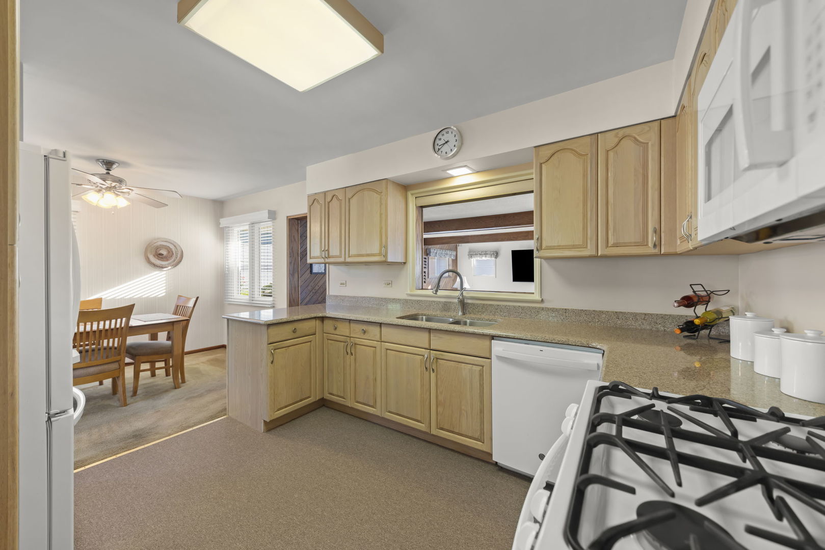 612 Wellner Road Naperville, IL 60540 - Photo 3 of 27 a kitchen with sink a stove and white cabinets
