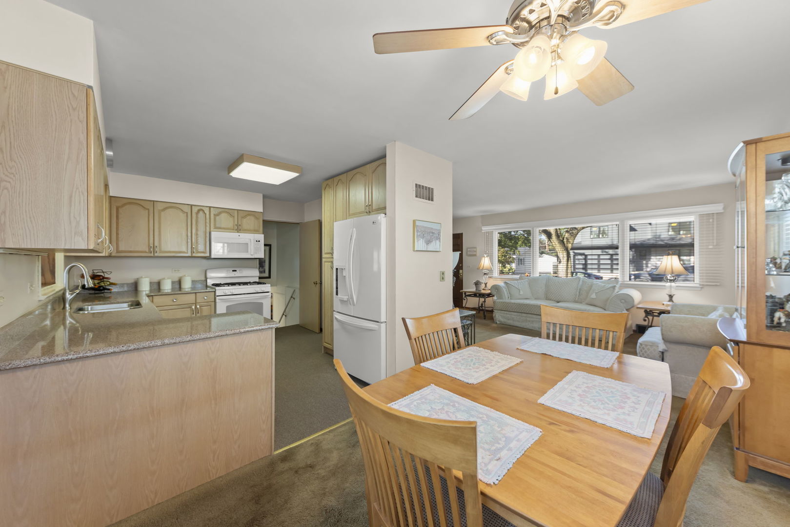 612 Wellner Road Naperville, IL 60540 - Photo 6 of 27 a kitchen with stainless steel appliances granite countertop a sink a stove a refrigerator with a dining table and chairs