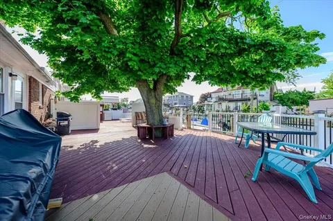 a view of a deck with table and chairs a barbeque with wooden floor and fence