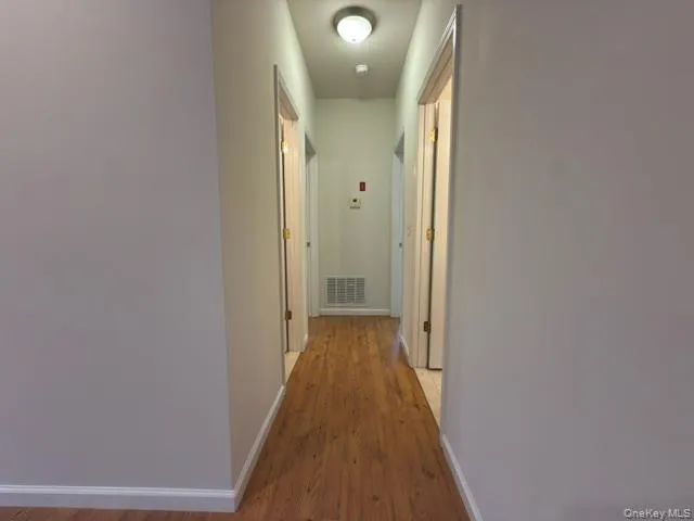 a view of a hallway with wooden floor