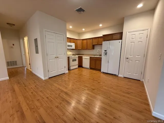 a view of a kitchen with refrigerator and white cabinets