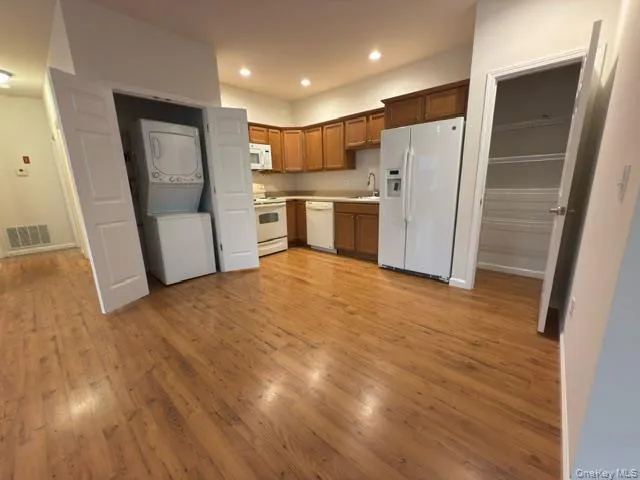 a kitchen with stainless steel appliances a refrigerator and wooden floor