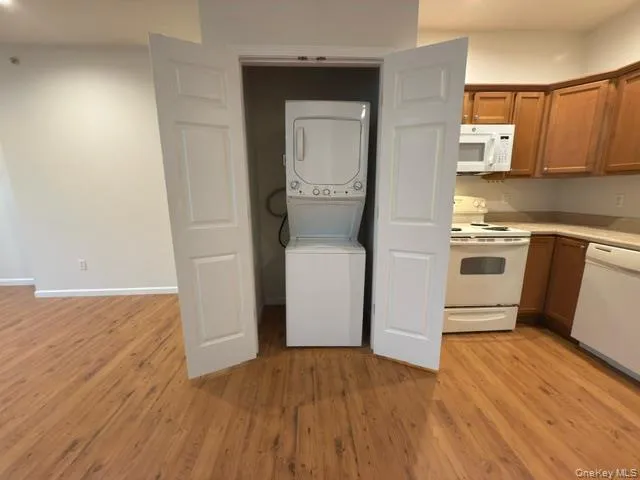 a kitchen with a white cabinets and wooden floor