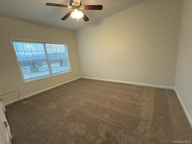en empty room with windows and chandelier fan