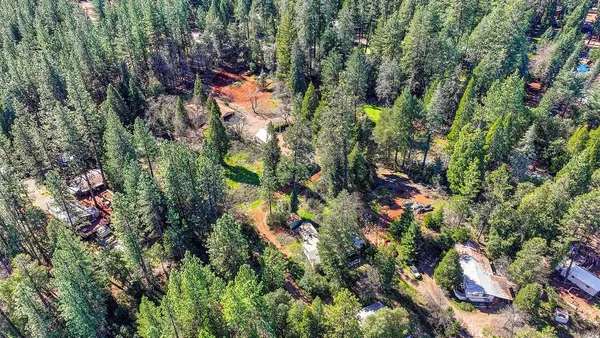 an aerial view of residential houses with outdoor space and trees