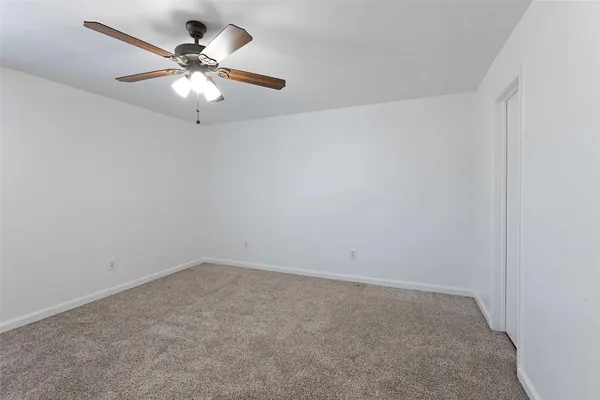 an empty room with a chandelier fan