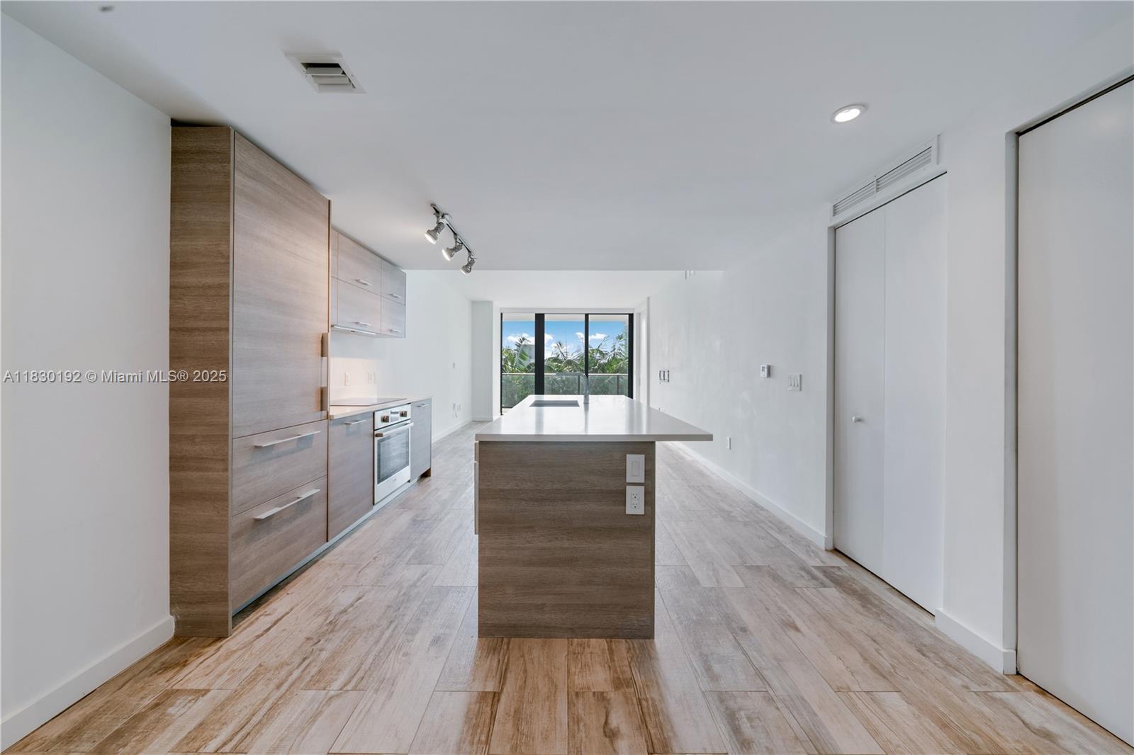 650 Northeast 32nd Street, Unit 802 Miami, FL 33137 - Photo 4 of 33 a kitchen with wooden floors and white cabinets