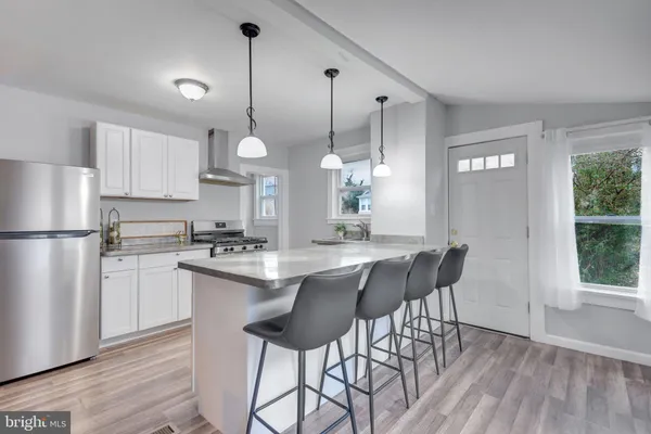 a kitchen with stainless steel appliances granite countertop white cabinets and wooden floor