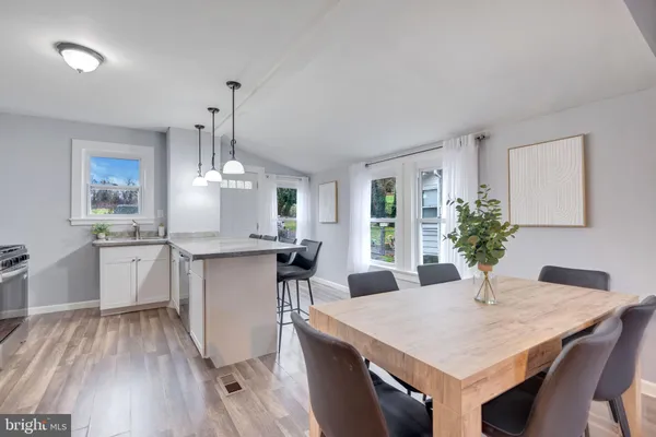 a kitchen with a table chairs sink and cabinets
