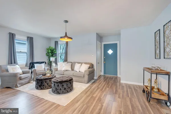 a living room with furniture a dining table with wooden floor and windows