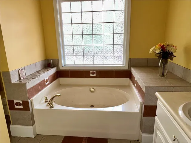 a white bath tub sitting in a bathroom next to a window
