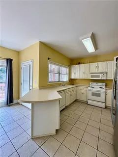 a kitchen with a sink window and cabinets