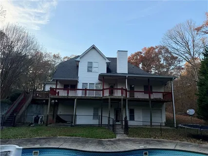 a view of a house with wooden deck and backyard