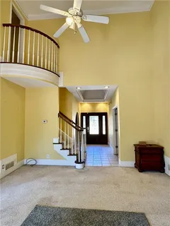 an empty room with windows and ceiling fan