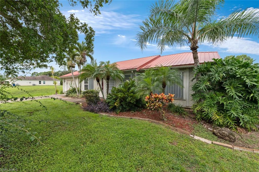 17520 Duquesne Road Fort Myers, FL 33967 - Photo 6 of 26 a front view of a house with a yard and a garden