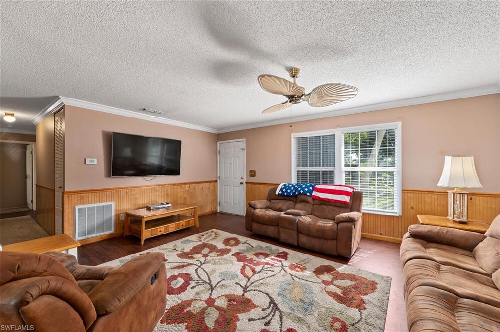17520 Duquesne Road Fort Myers, FL 33967 - Photo 9 of 26 a living room with furniture and a flat screen tv