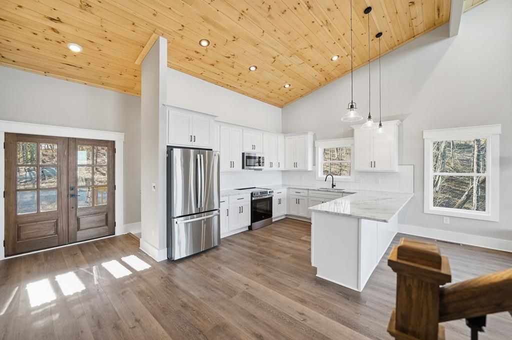 1176 Jewel Court Northeast Ranger, GA 30734 - Photo 12 of 57 a kitchen with stainless steel appliances granite countertop a refrigerator a sink dishwasher a stove and white countertops with wooden floor