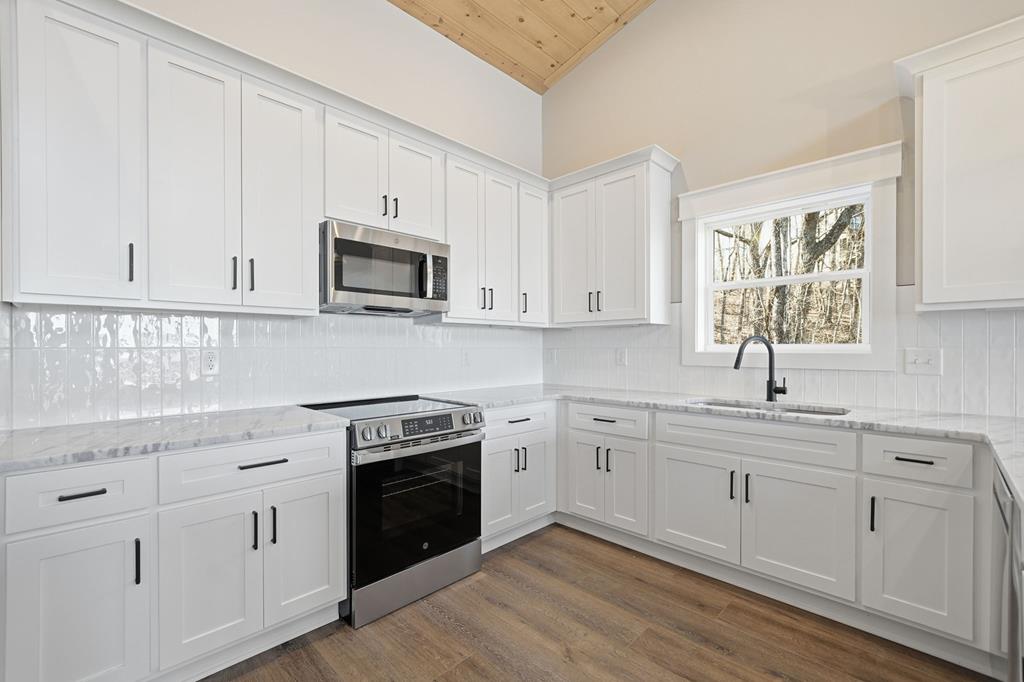 1176 Jewel Court Northeast Ranger, GA 30734 - Photo 17 of 57 a kitchen with white cabinets and white appliances