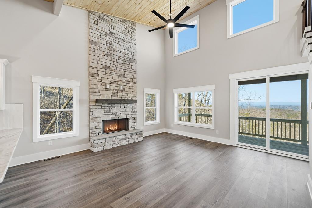 1176 Jewel Court Northeast Ranger, GA 30734 - Photo 5 of 57 an empty room with wooden floor fireplace and windows
