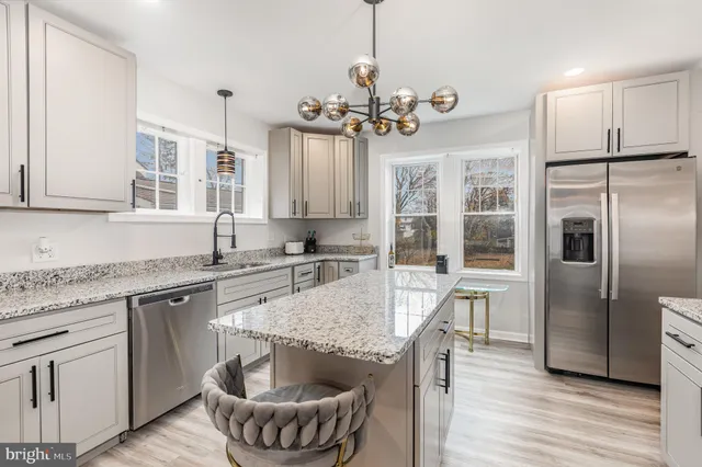 a kitchen with kitchen island granite countertop a sink a center island stainless steel appliances and cabinets