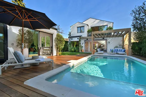 a view of a patio with table and chairs under an umbrella