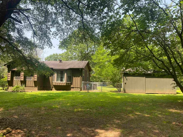 a view of a house with a tree in the yard