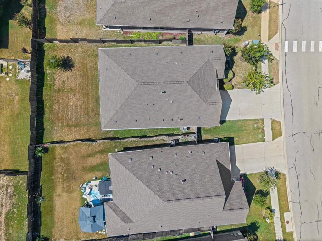 277 Spinnaker Loop Kyle, TX 78640 - Photo 33 of 38 An aerial perspective showcases a neat neighborhood layout with fenced backyards and paved driveways leading to a public street.