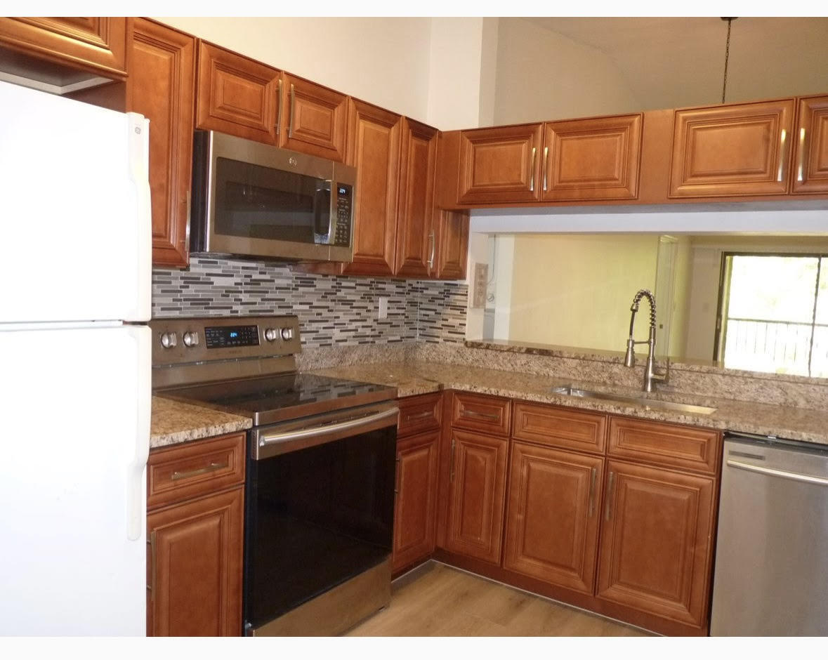 3130 Millwood Terrace, Unit 2120 Boca Raton, FL 33431 - Photo 6 of 15 a kitchen with stainless steel appliances a sink stove and microwave