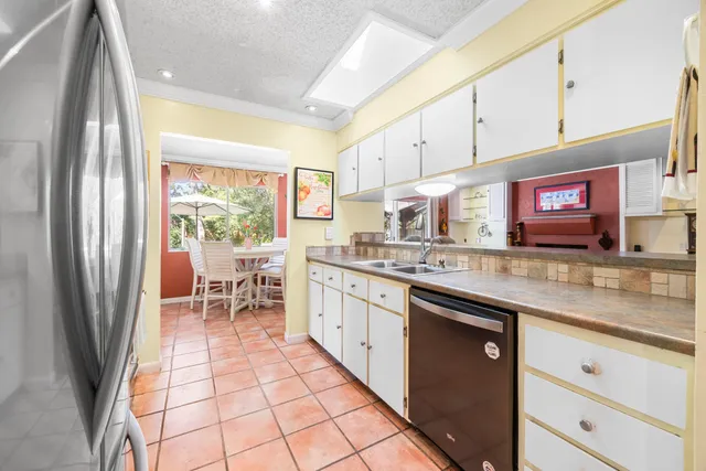 a kitchen with stainless steel appliances granite countertop a refrigerator and a sink